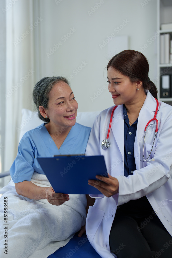 A friendly doctor talks with a retired female patient resting in bed. Full recovery after illness Doctor gives advice on health care Physical examination, treatment advice, medicine, health insurance A friendly doctor talks with a retired female patient resting in bed. Full recovery after illness Doctor gives advice on health care Physical examination, treatment advice, medicine, health insurance