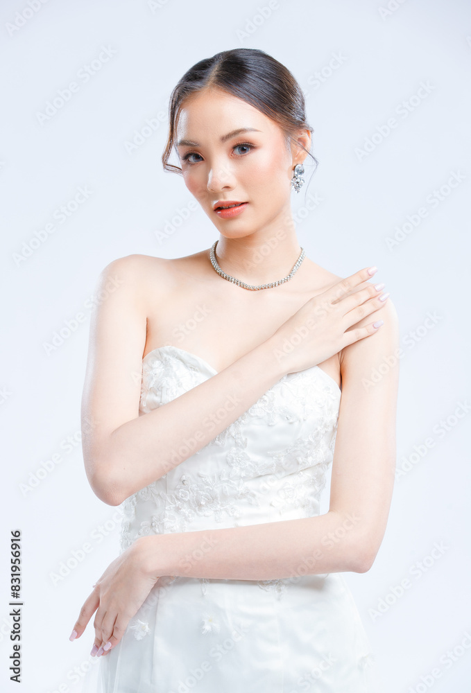 Asian young beautiful female portrait attractive model of bride wearing fashion wedding dress, luxury delight make-up, hairstyle, standing looking camera isolated white background studio indoor photo Asian young beautiful female portrait attractive model of bride wearing fashion wedding dress, luxury delight make-up, hairstyle, standing looking camera isolated white background studio indoor photo