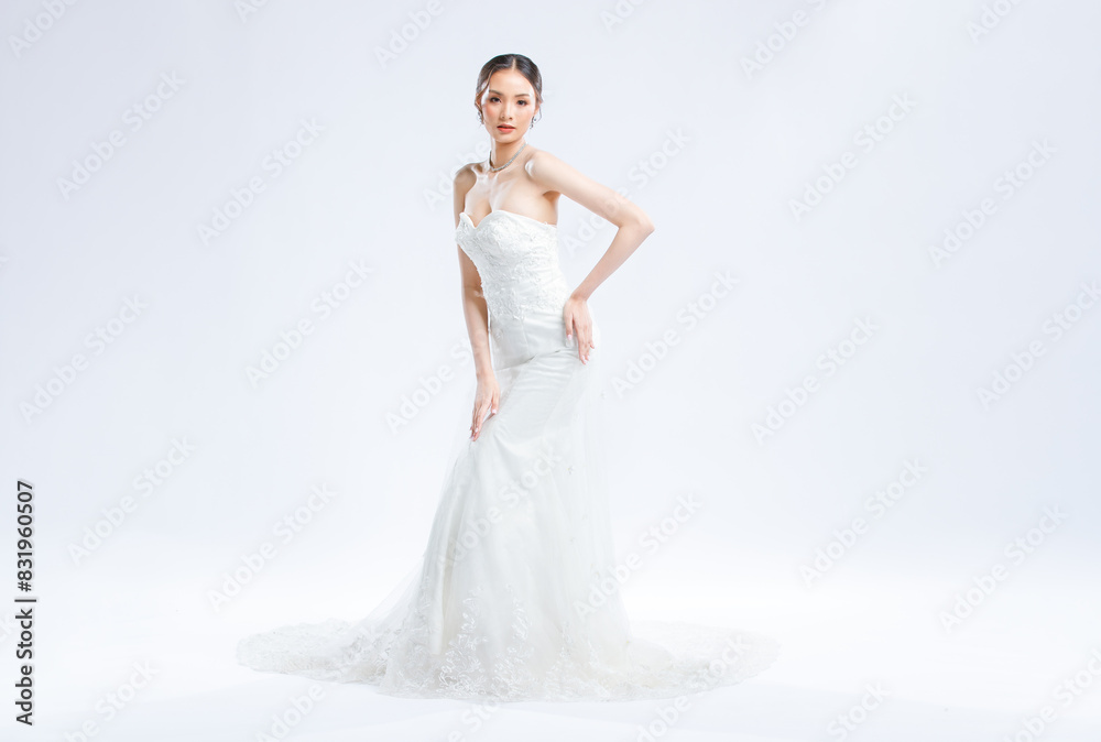 Asian young beautiful female portrait attractive model of bride wearing fashion wedding dress, luxury delight make-up, hairstyle, standing looking camera isolated white background studio indoor photo Asian young beautiful female portrait attractive model of bride wearing fashion wedding dress, luxury delight make-up, hairstyle, standing looking camera isolated white background studio indoor photo