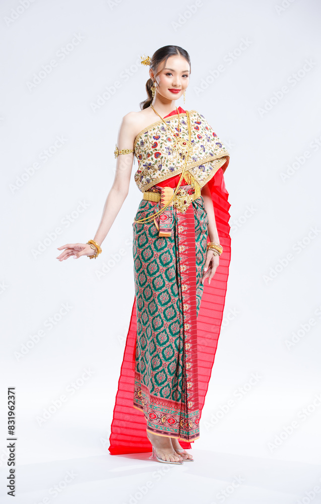 Asian young female portrait beautiful bride woman in vintage traditional Thai costumes, gold and red color dress, standing smile looking camera isolated white background studio Asian young female portrait beautiful bride woman in vintage traditional Thai costumes, gold and red color dress, standing smile looking camera isolated white background studio
