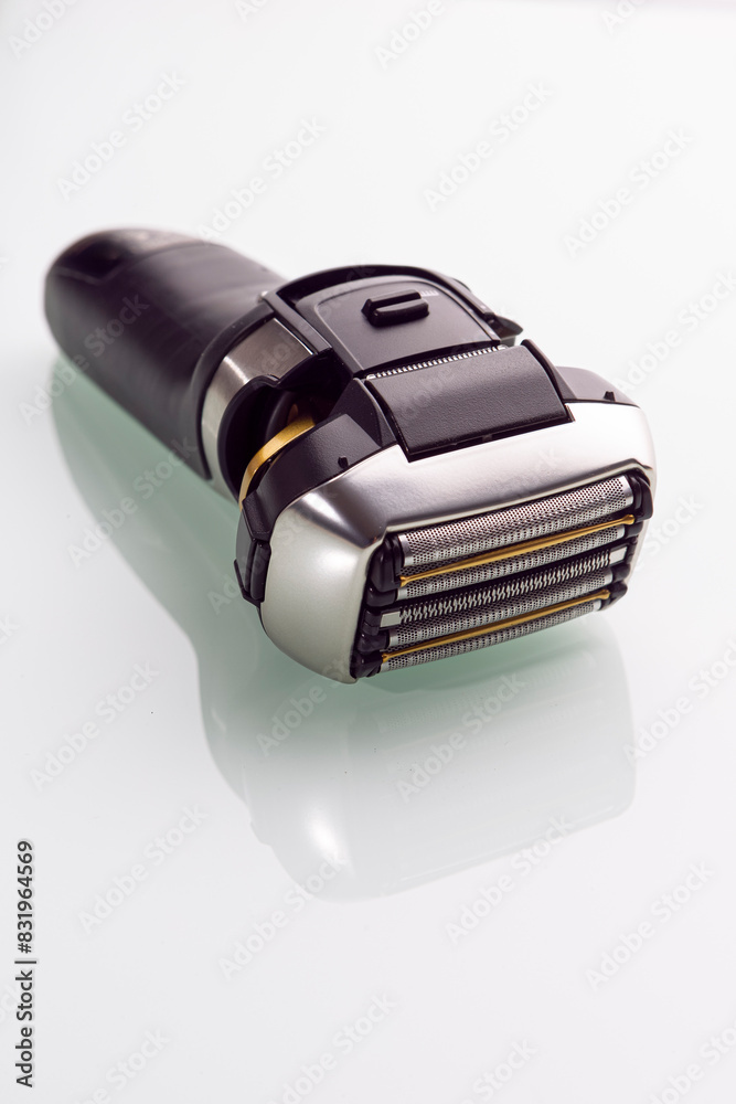 Healthcare Concepts. Closeup and Upper View of Of Modern Electric 5 Blades Stainless Steel Shaver Over Reflective White Healthcare Concepts. Closeup and Upper View of Of Modern Electric 5 Blades Stainless Steel Shaver Over Reflective White