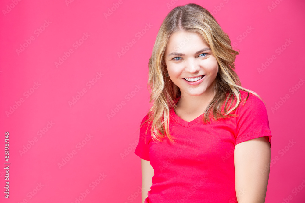 Smiling Happy Winsome Caucasian Blond Girl In Coral T-shirt Posing While Showing Positive Expression Over Coral Pink Background. Smiling Happy Winsome Caucasian Blond Girl In Coral T-shirt Posing While Showing Positive Expression Over Coral Pink Background.