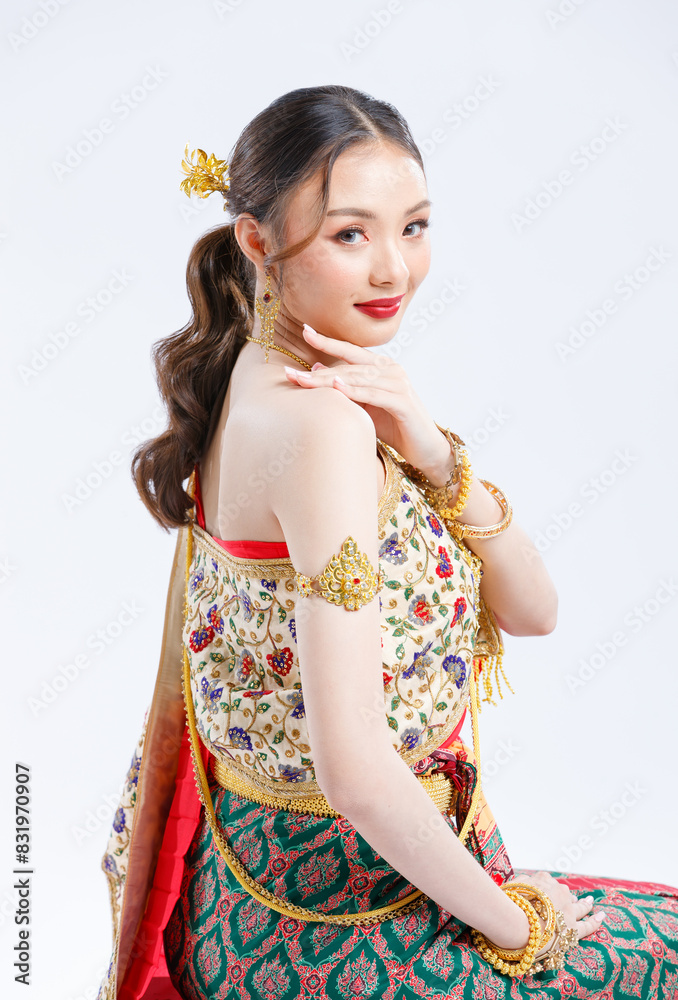 Half body shot, Asian young female portrait beautiful bride woman in vintage traditional Thai costumes, gold and red color dress, sitting smile looking camera isolated white background studio.