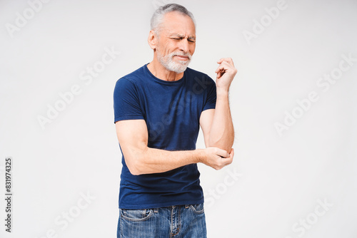 Canvas Print Middle age gray-haired bearded man suffering from pain in elbow on white backgro