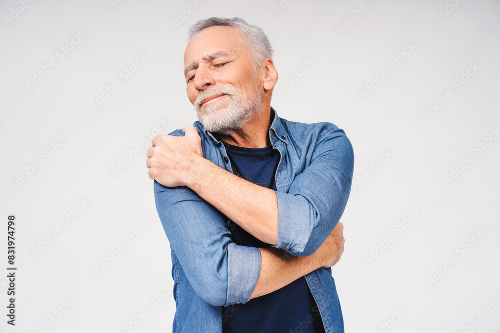 Portrait of relaxed mature gray-haired man hugging himself closing eyes isolated on white Portrait of relaxed mature gray-haired man hugging himself closing eyes isolated on white