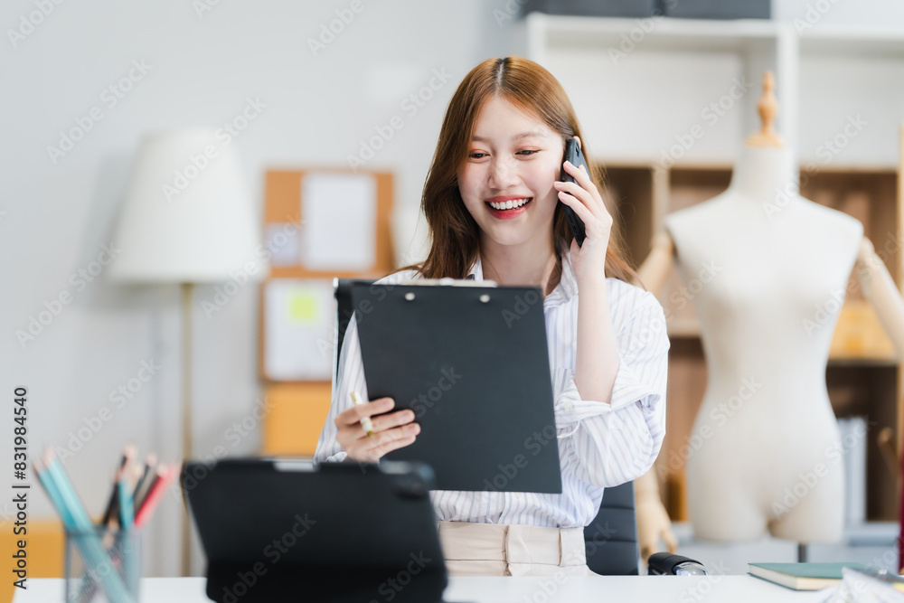 A young Asian businesswoman efficiently manages SMEs, utilizing her desk, tablet, laptop to handle online orders and live streams, showcasing entrepreneurial prowess in the dynamic market landscape. A young Asian businesswoman efficiently manages SMEs, utilizing her desk, tablet, laptop to handle online orders and live streams, showcasing entrepreneurial prowess in the dynamic market landscape.