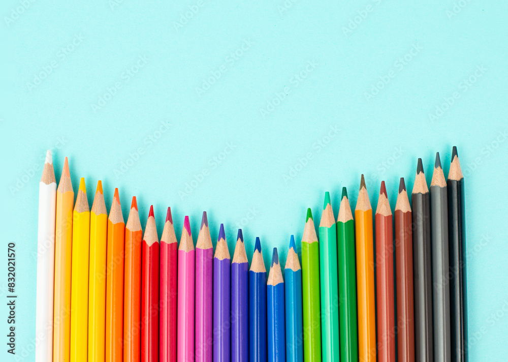Color pencils collection in a row, back to school, drawing supplies, blue background with copy space Color pencils collection in a row, back to school, drawing supplies, blue background with copy space