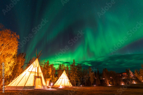 Amazing northern lights dancing over the light up Tipi or Tepees at Aurora Village in Yellowknife, Northwest Territories, Canada.
