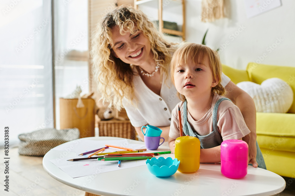 A curly-haired mother and her toddler daughter joyfully engage in Montessori-based play at home with colorful toys. A curly-haired mother and her toddler daughter joyfully engage in Montessori-based play at home with colorful toys.