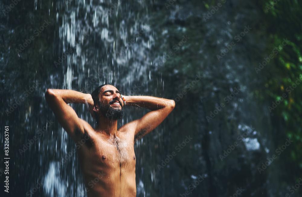 Fototapeta premium Man, waterfall and happy in nature on travel trip, eyes closed and freedom on adventure in sustainable environment. Bangladesh, outdoor and traveler on summer holiday, forest and journey or mountain