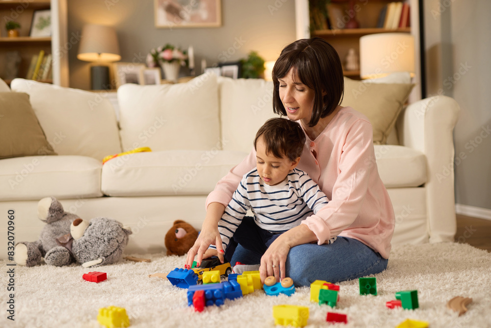 Mother and her baby boy playing with colored toy blocks at home Mother and her baby boy playing with colored toy blocks at home