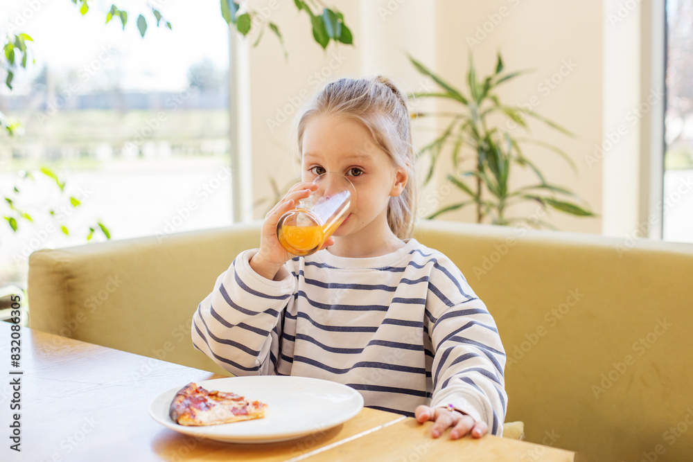 Child Drinking Orange Juice with Pizza