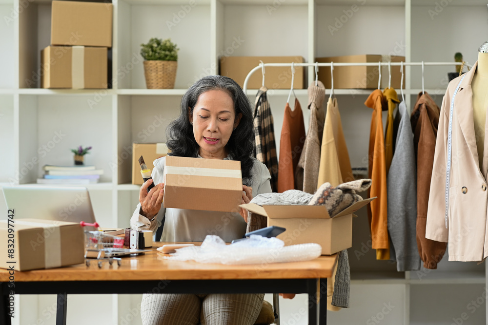Middle age female entrepreneur checking order before sending to customers. E-commerce concept Middle age female entrepreneur checking order before sending to customers. E-commerce concept