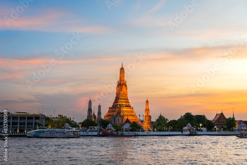 Wat Arun (Temple of Dawn) along Chao Phraya river at sunset, Bangkok, Thailand photo