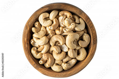 a wooden bowl filled with cashews on top of a white surface