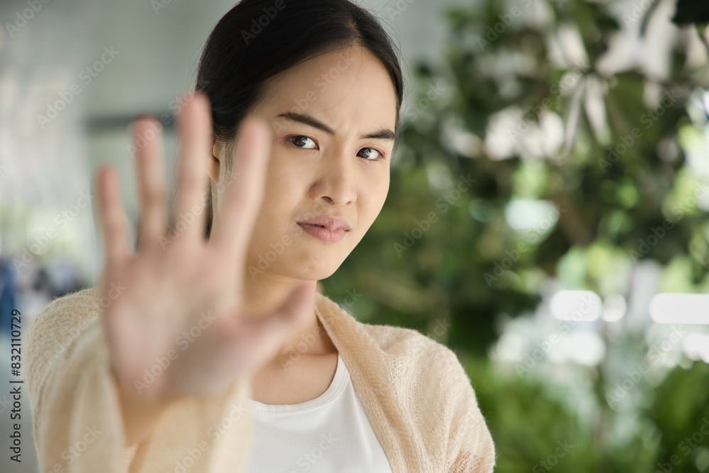 Halt, Stop it, Asian Woman Expressing Refusal, showing Stop Hand Sign to Communicate Prohibition and Rejection Halt, Stop it, Asian Woman Expressing Refusal, showing Stop Hand Sign to Communicate Prohibition and Rejection