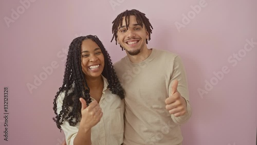 Beautiful couple exhibiting happy signals, upstanding sign of positive approval and excellent joy over isolated pink background