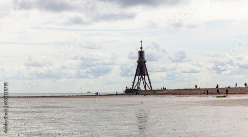 Panoramic photo of the lighthouse in Cuxhaven at low tide and bad weather. Thick dark clouds over the bay