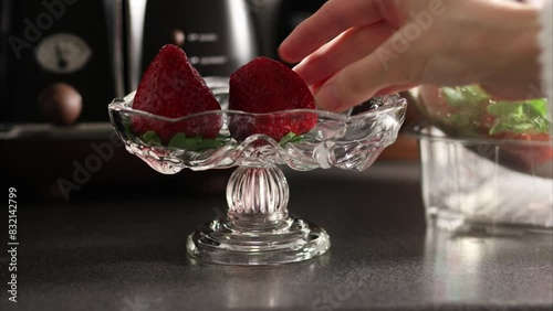 A woman puts strawberries in a vase. Video 4k footage