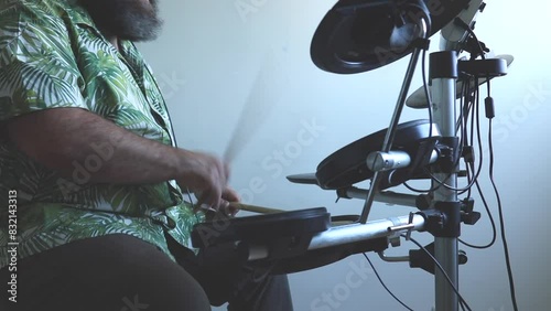 serious male drummer playing electronic drum kit at home. Rock music performance. 