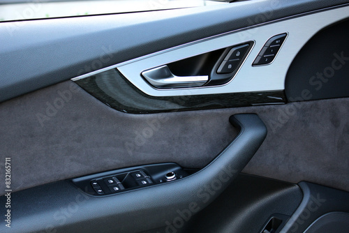 Door handle and control buttons in premium car. Window control buttons. Car door leather trim. 