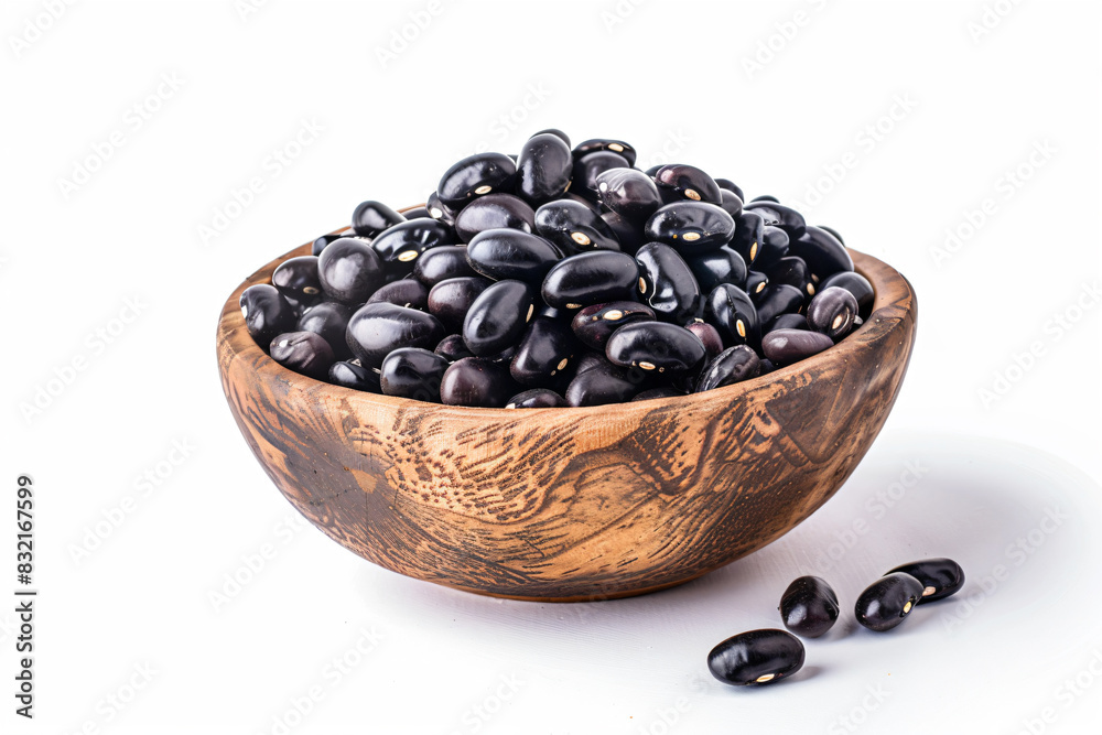 a wooden bowl filled with black beans on a white surface a wooden bowl filled with black beans on a white surface