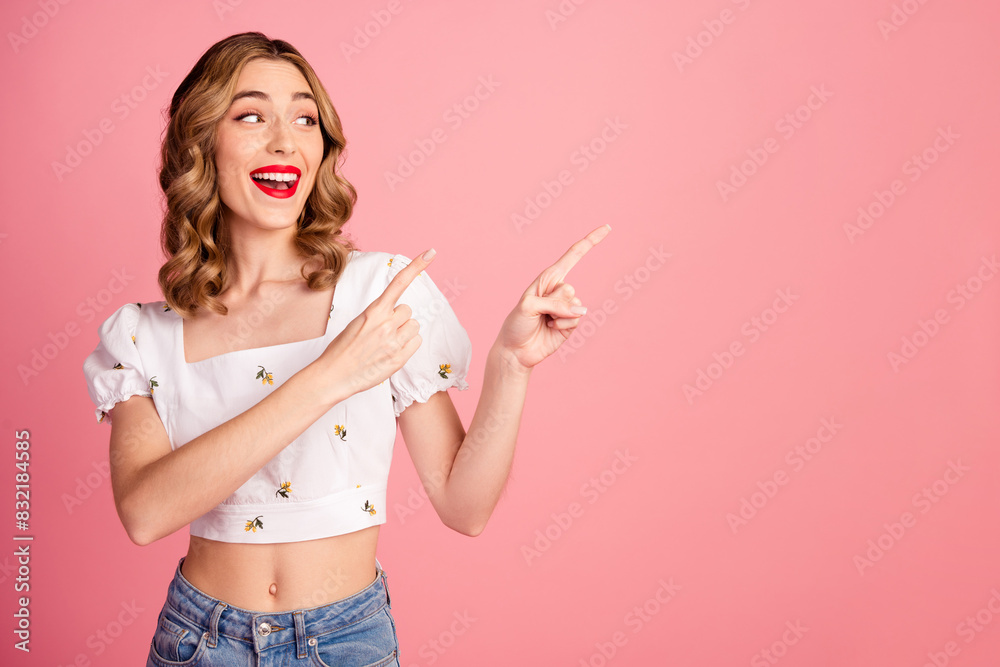 Photo portrait of pretty young girl point look amazed empty space wear trendy white outfit hairdo isolated on pink color background Photo portrait of pretty young girl point look amazed empty space wear trendy white outfit hairdo isolated on pink color background