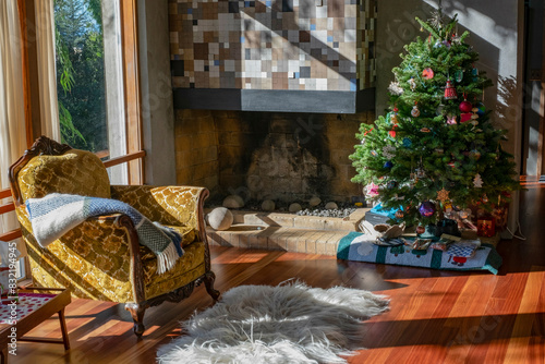 A cozy living room decorated for Christmas with a festive tree, a fireplace, and an armchair draped with a blanket. photo