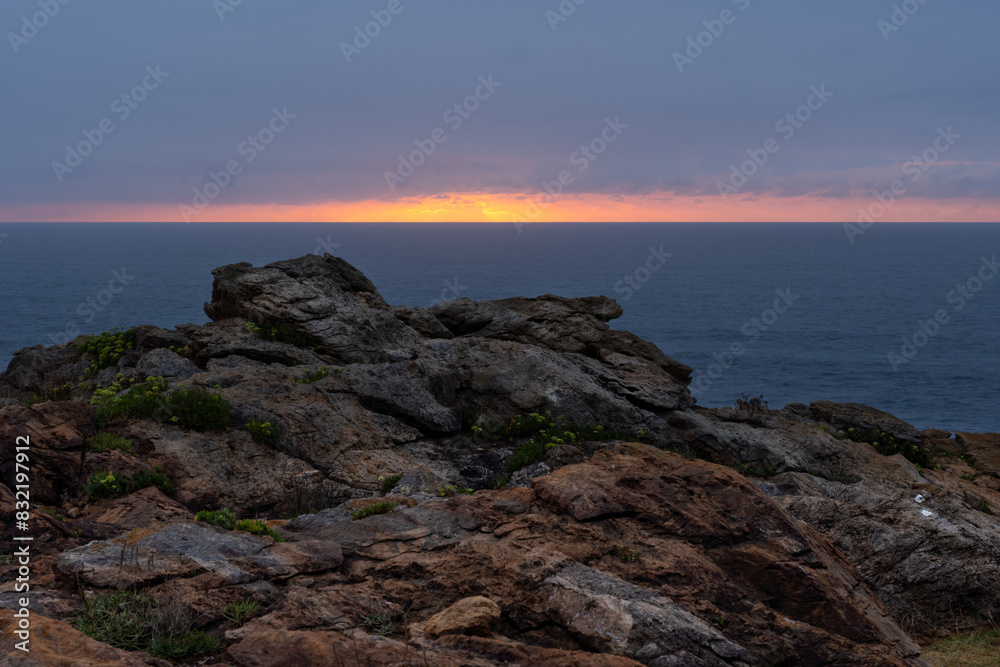 sunset on the coast, rocks and dramatic sky in purple sunset on the coast, rocks and dramatic sky in purple