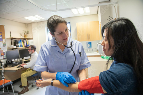 Nurse examining a patient's arm for blood pressure and pulse photo
