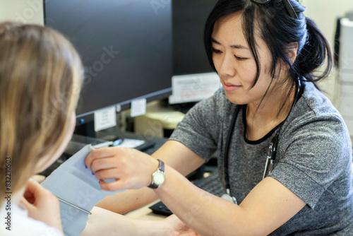 Doctor preparing blood pressure test with a patient in a medical practice photo