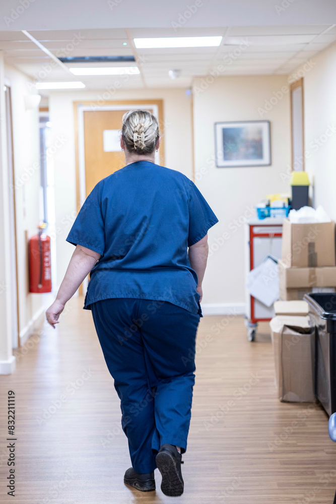 Medical professional walking down a hospital corridor Medical professional walking down a hospital corridor