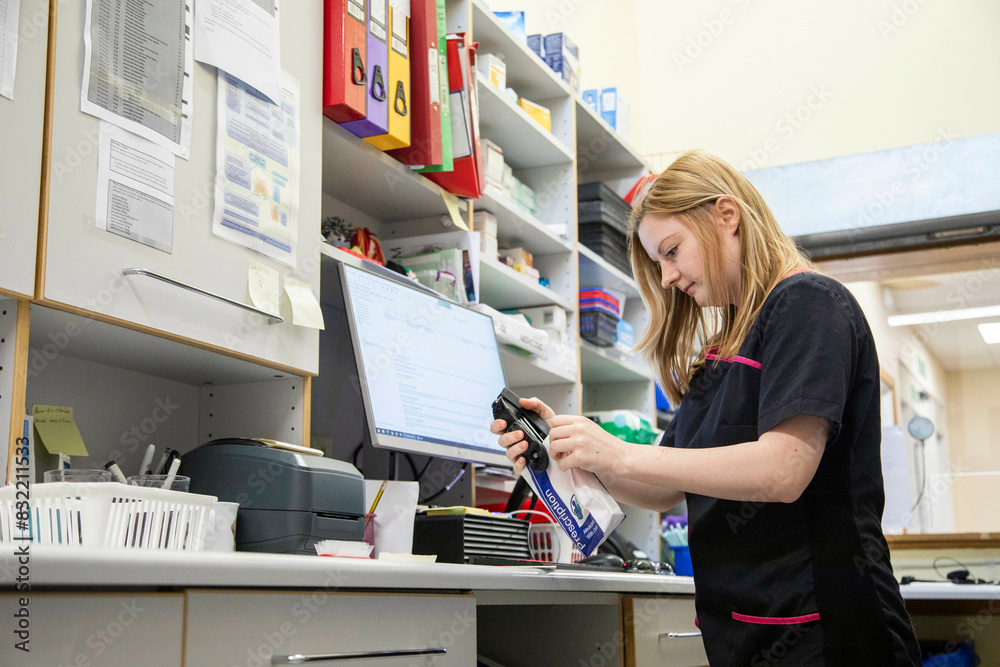 Veterinary technician scanning item at clinic workstation Veterinary technician scanning item at clinic workstation