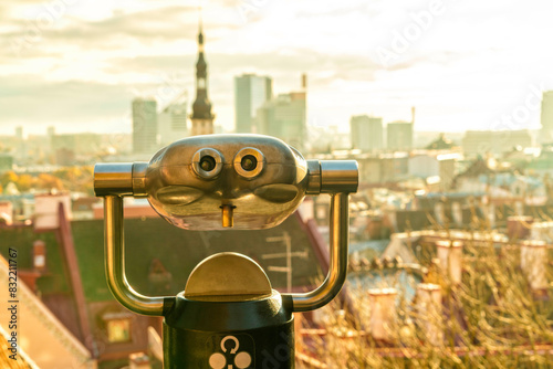 Coin-operated binoculars overlooking a city at sunset. photo