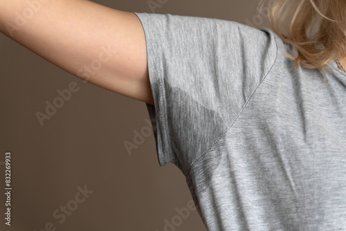 Obraz na płótnie Close-up of a young woman shows a wet armpit on a gray T-shirt. Concept of health, sports w salonie