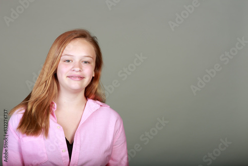 A girl with a pink shirt is smiling