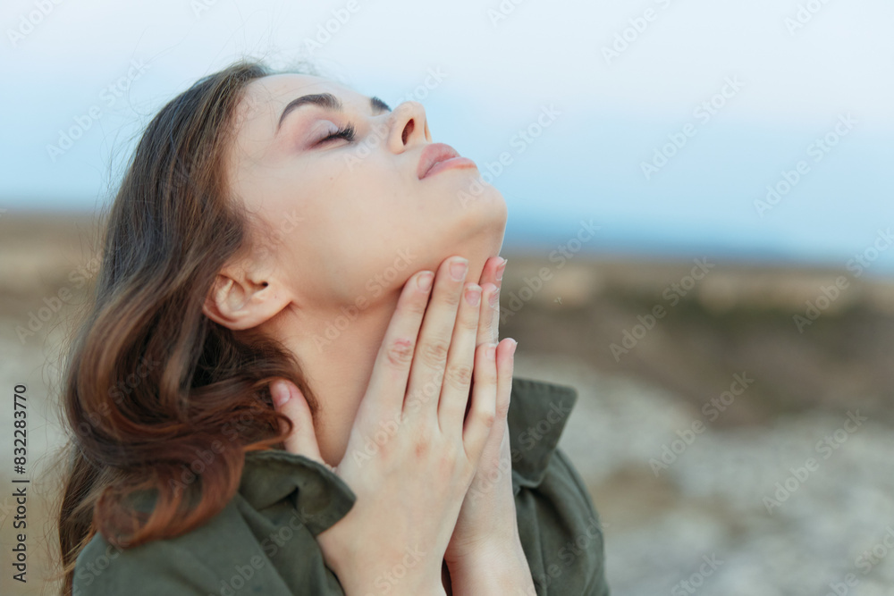Gorgeous female model gracefully poses on the ground, touching her neck with hands in elegant fashion Gorgeous female model gracefully poses on the ground, touching her neck with hands in elegant fashion
