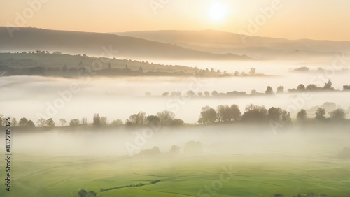 Misty sunrise over a serene countryside landscape  with fog hanging low in the valleys