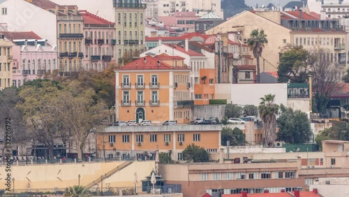 Aerial view over the center of Lisbon to the viewpoint called Miradouro de Sao Pedro de Alcantara timelapse. Colorful houses on a hill. People in the park and cafe with tables. Portugal photo