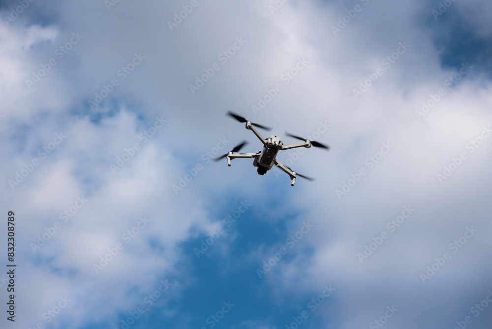 Flying drone on the blue sky with clouds Flying drone on the blue sky with clouds