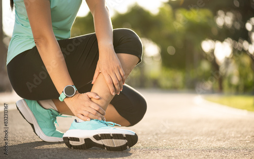 Fototapeta Naklejka Na Ścianę i Meble -  Ankle sprained. Young woman suffering from an ankle injury while exercising and running. Healthcare and sport concept.