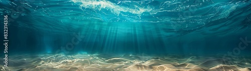 Stunning underwater view with sunlight rays penetrating the water, illuminating the sandy ocean floor. Ideal for nature, ocean, and marine themes. photo