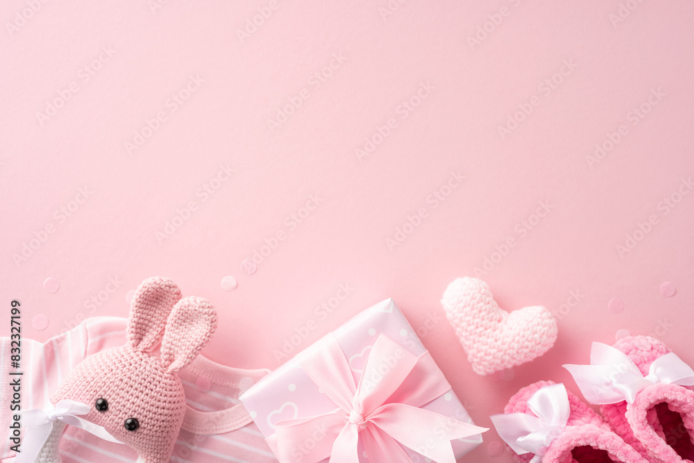 Φωτογραφία Pink baby gifts and accessories including knitted toy, heart, and baby shoes on