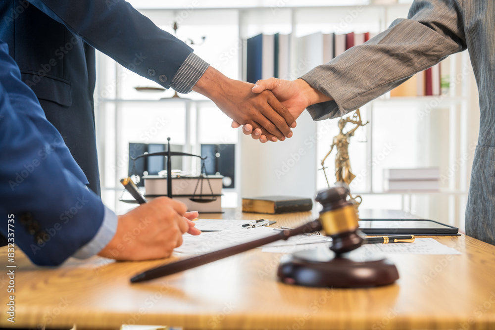 A team meeting of business people and a lawyer in formal suits is taking place at a desk, discussing a contract and various aspects of the law and litigation. A team meeting of business people and a lawyer in formal suits is taking place at a desk, discussing a contract and various aspects of the law and litigation.