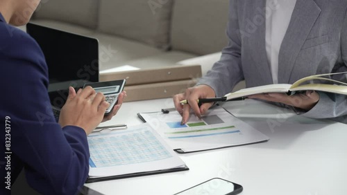 Two Asian businesswomen collaborate on stock market strategies and financial services, exchanging comments and suggestions on loan applications and investment opportunities.