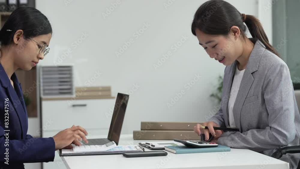 Two Asian businesswomen collaborate on stock market strategies and financial services, exchanging comments and suggestions on loan applications and investment opportunities. Two Asian businesswomen collaborate on stock market strategies and financial services, exchanging comments and suggestions on loan applications and investment opportunities.