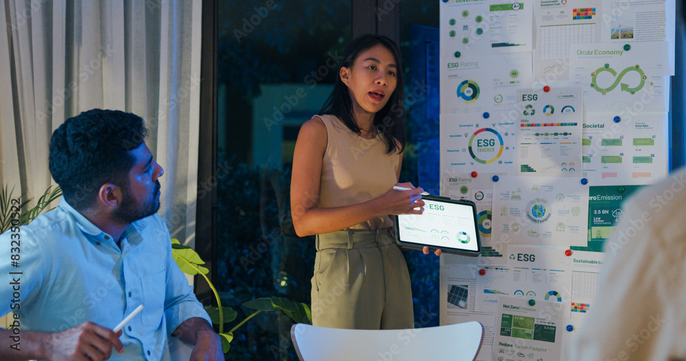 © tirachard - Group diverse Asia businesspeople talk ESG strategies risk management workshop night, SDGs, global warming, green finance and investment and net zero waste lifestyles in boardroom training building.