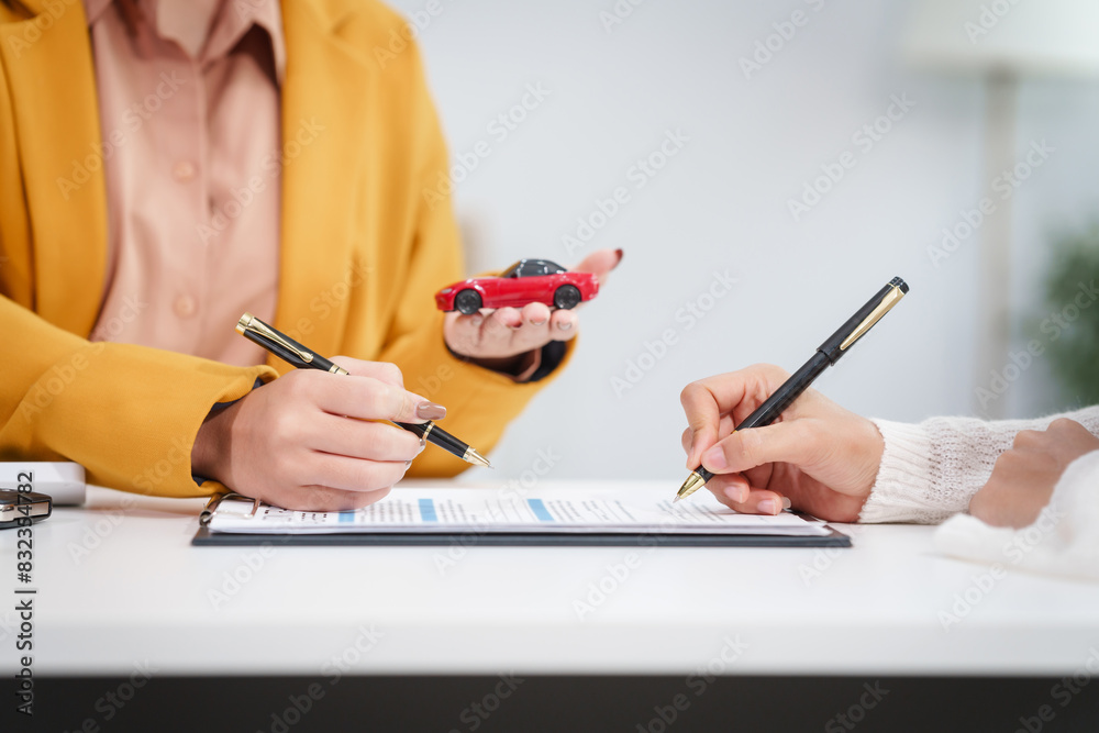 © NanSan - Asian businesswoman and a salesman discuss car sales, insurance, and financing with a customer at a desk, covering used car loans, premiums, deductibles, and various insurance coverage options. © NanSan - Asian businesswoman and a salesman discuss car sales, insurance, and financing with a customer at a desk, covering used car loans, premiums, deductibles, and various insurance coverage options.
