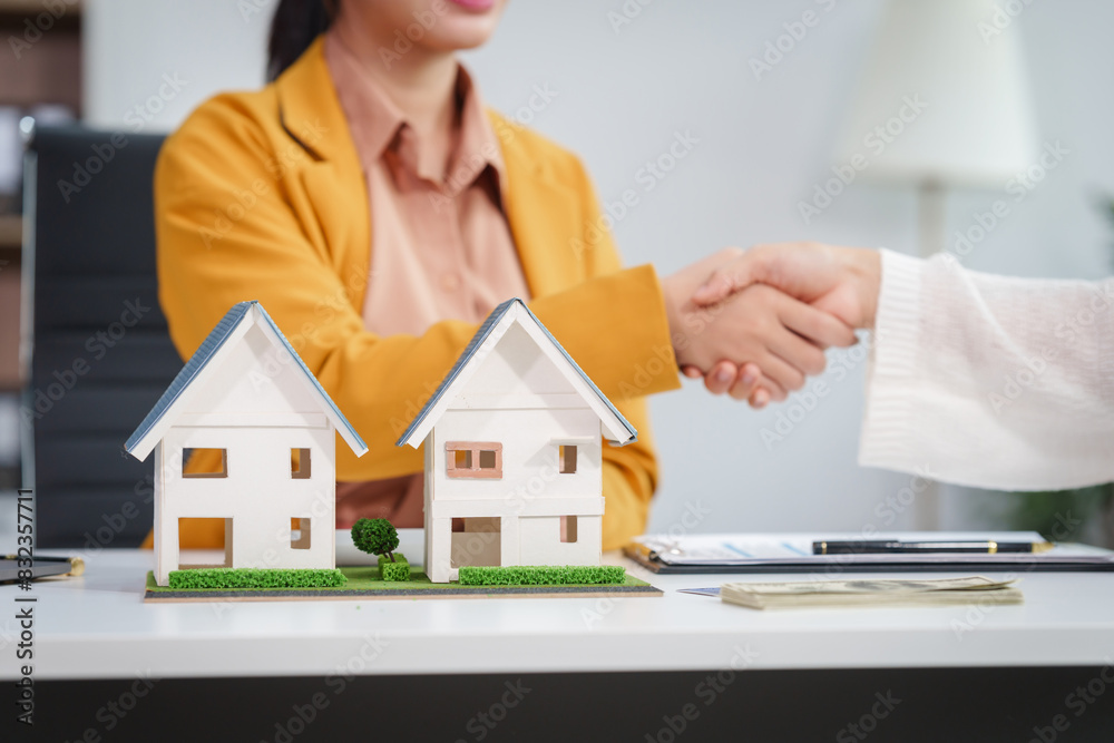 Asian businesswoman discusses home purchase contracts with clients at her desk, focusing on loans, mortgages, and other financial aspects of real estate transactions. Asian businesswoman discusses home purchase contracts with clients at her desk, focusing on loans, mortgages, and other financial aspects of real estate transactions.