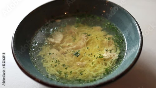 Close-up of chicken soup with vermeil and herbs in a plate photo